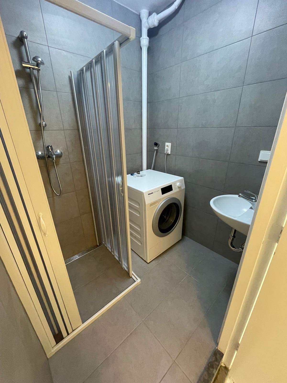 Badkamer met douche en wastafel.